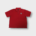 Red Nike polo shirt featuring an embroidered round golf association logo on the chest