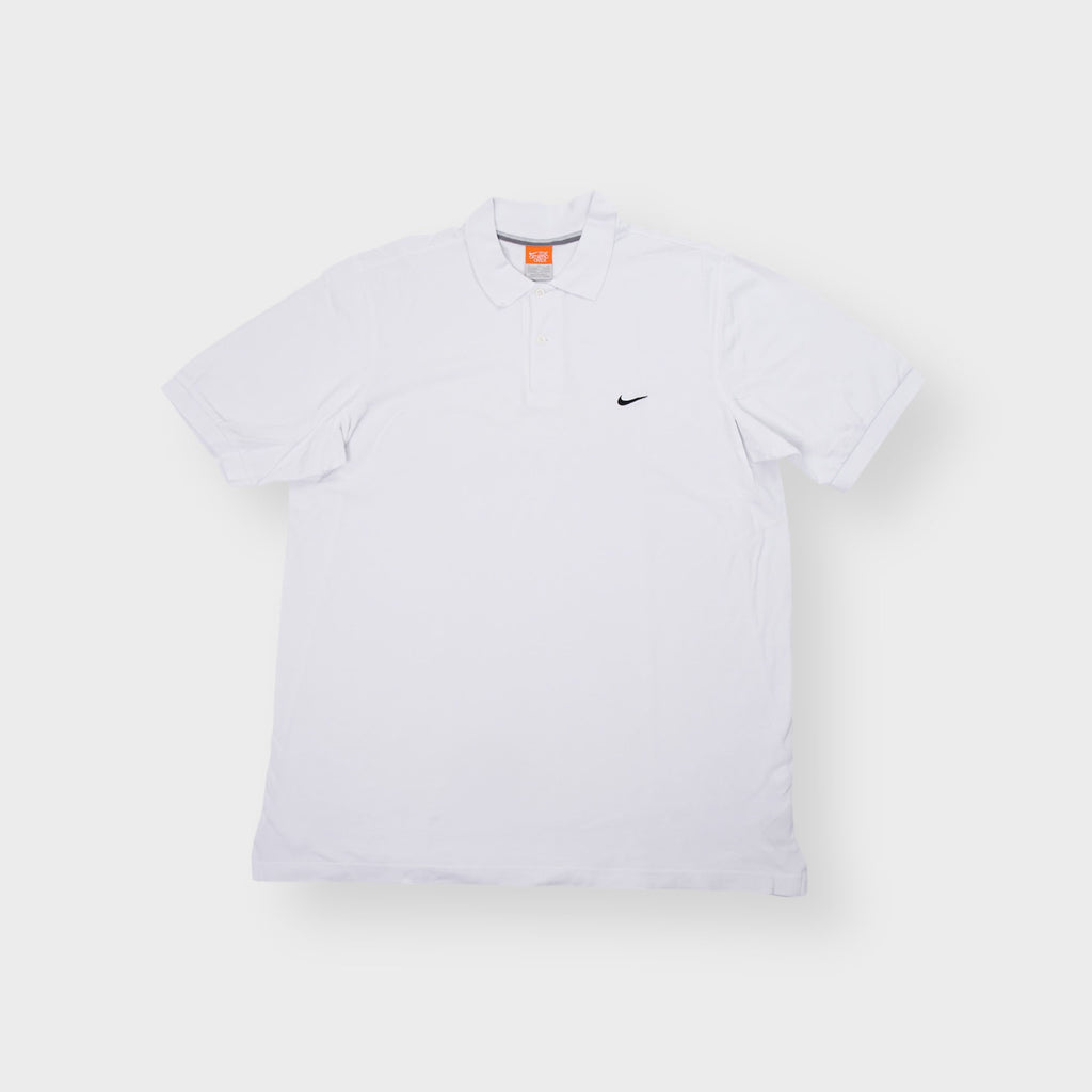 Nike short sleeve polo shirt in white featuring a small black swoosh logo embroidered on the chest