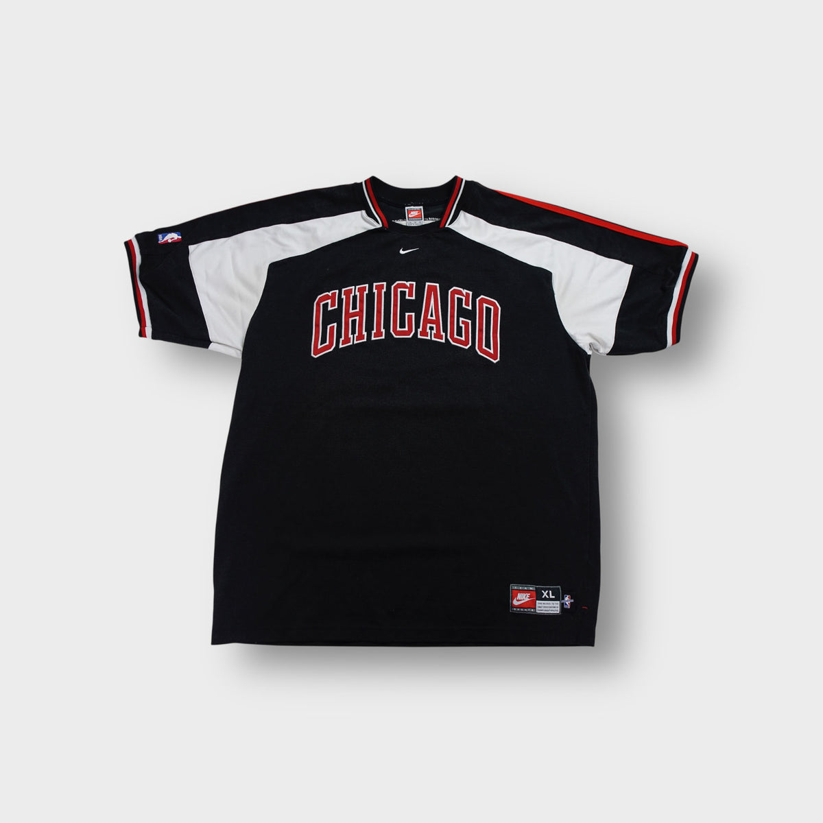 Black Nike Chicago Bulls shooting shirt with red embroidered chest lettering.