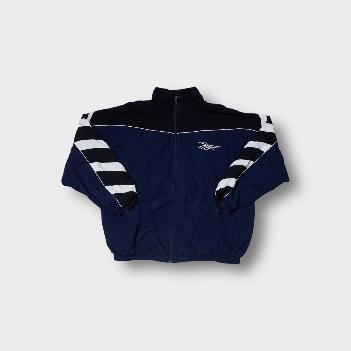 Reebok track jacket in navy blue with diagonal white and black sleeve stripes