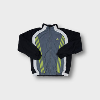 Adidas track jacket in grey and black with yellow three-stripe chest embroidery.