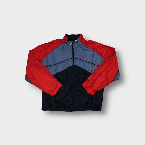 Nike track jacket in red, blue, and black with a chevron pattern and embroidered logo