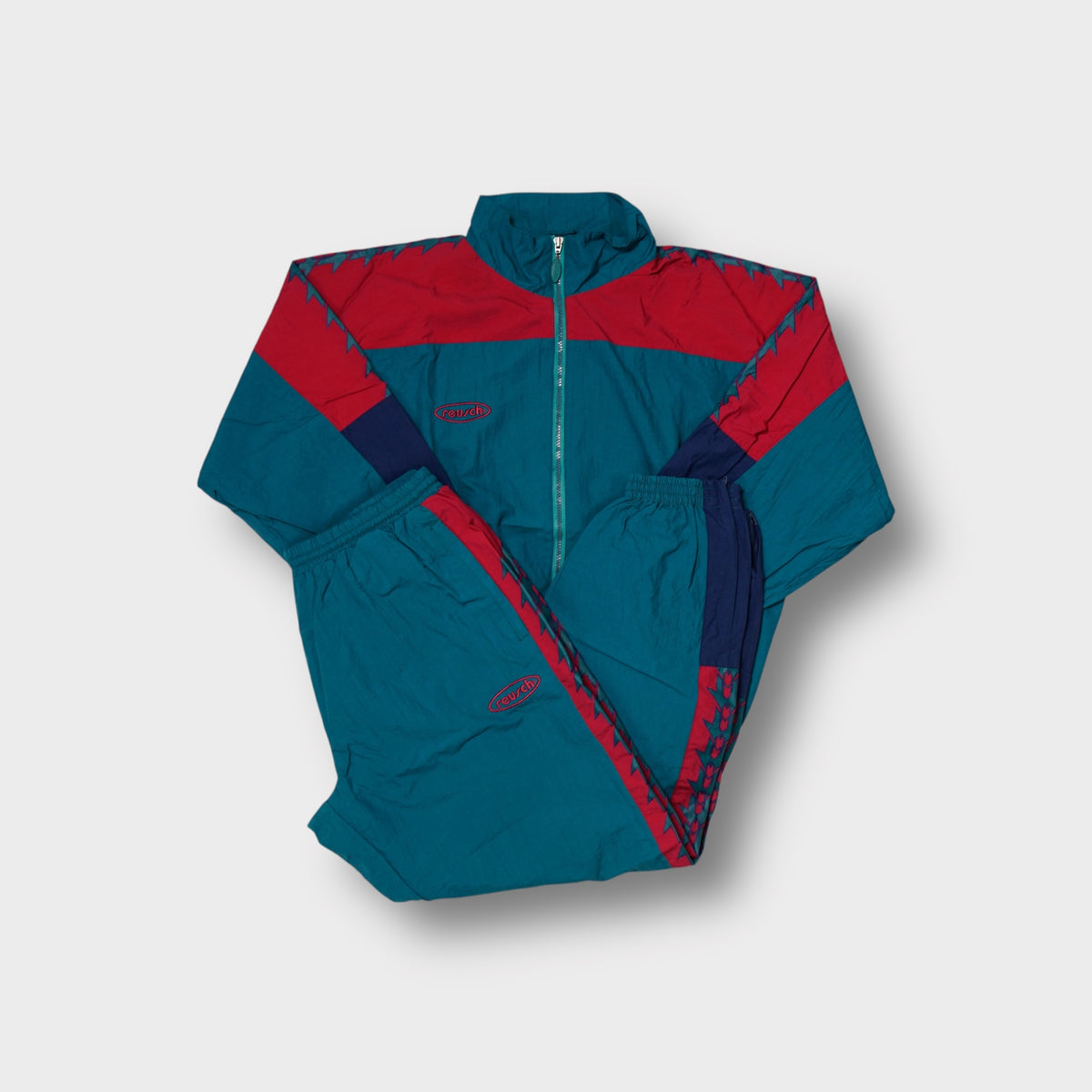 Reusch tracksuit in red and green with geometric sleeve side pattern