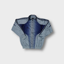 Load image into Gallery viewer, Adidas track jacket in light blue and navy featuring embroidered chest logo