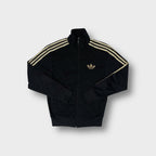 Adidas track jacket in black with metallic gold embroidered trefoil logo and sleeve stripes