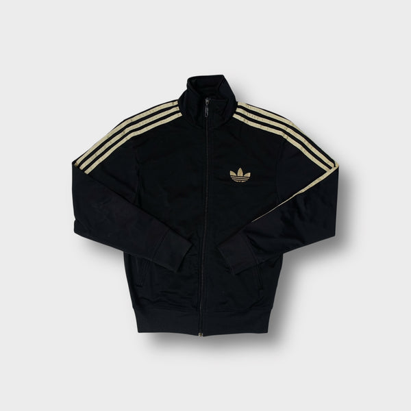 Adidas track jacket in black with metallic gold embroidered trefoil logo and sleeve stripes