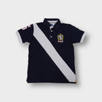 Solera polo shirt in navy featuring a white diagonal sash and embroidered chest crest