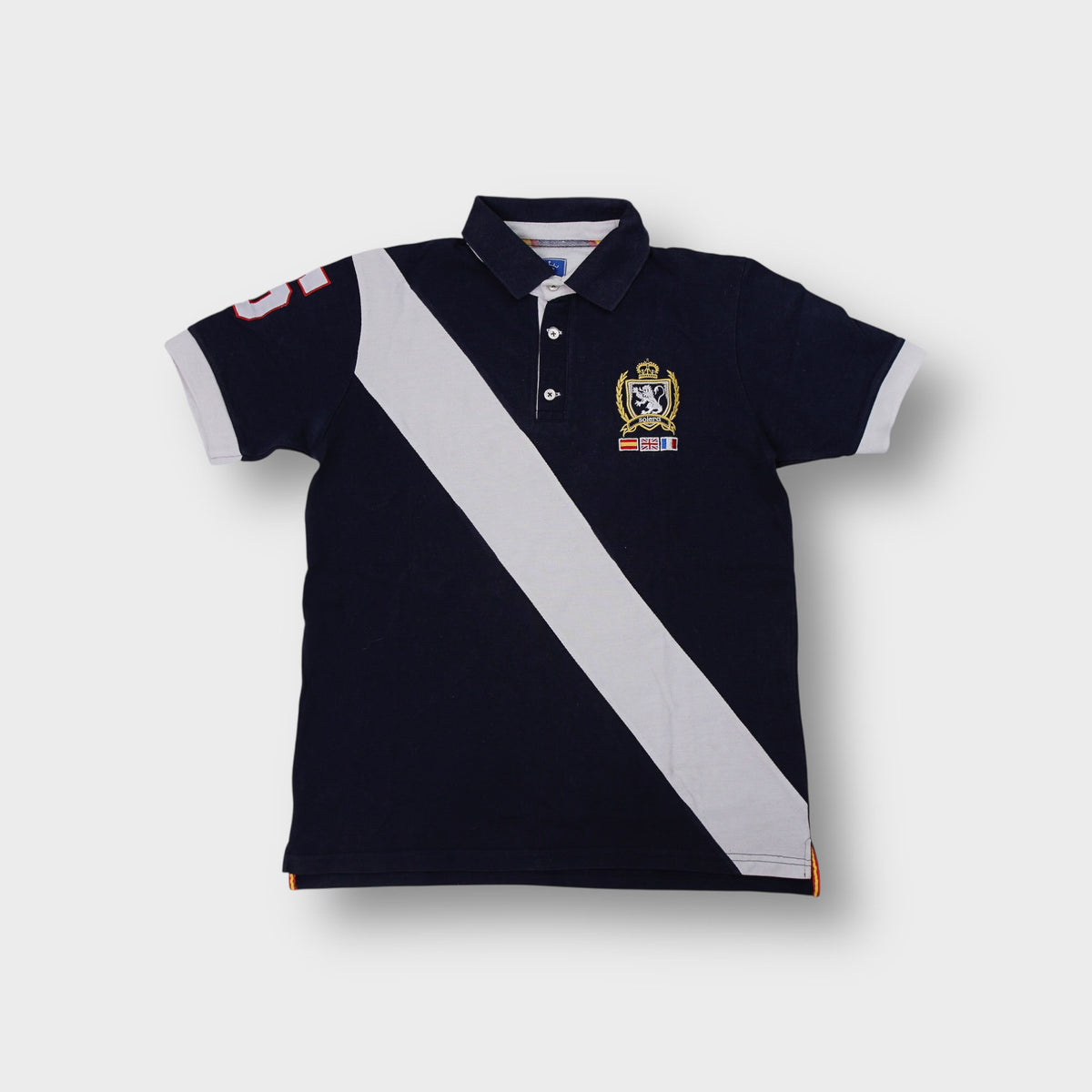 Solera polo shirt in navy featuring a white diagonal sash and embroidered chest crest