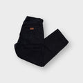Black Wrangler denim jeans with a brown leather logo patch on the back pocket