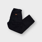 Black Wrangler denim jeans with a brown leather logo patch on the back pocket