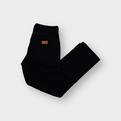 Wrangler denim jeans in black featuring a brown leather logo patch on the back pocket