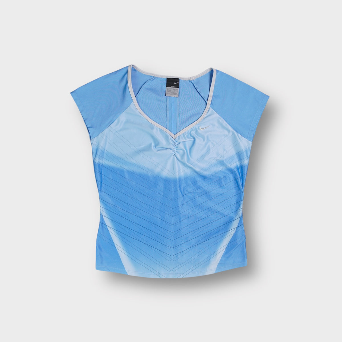 Nike shirt in blue with light blue gradient lines and embroidered swoosh logo
