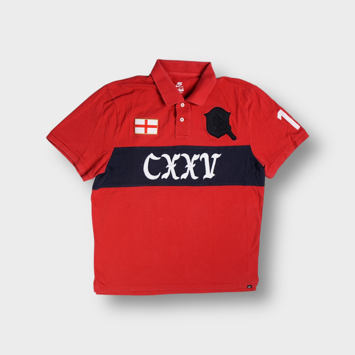 Nike red polo shirt with dark chest band featuring CXXV embroidery and England patch