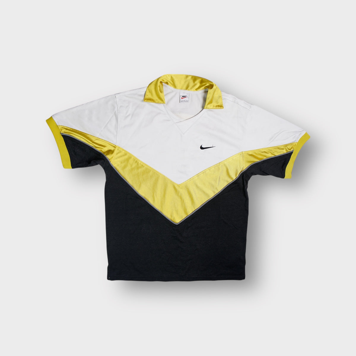 Nike shirt in white and yellow featuring a chevron pattern and small chest swoosh