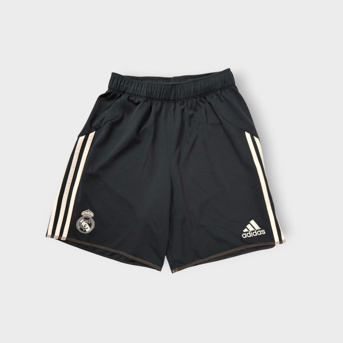 Adidas Real Madrid black sports shorts featuring three white stripes and club crest