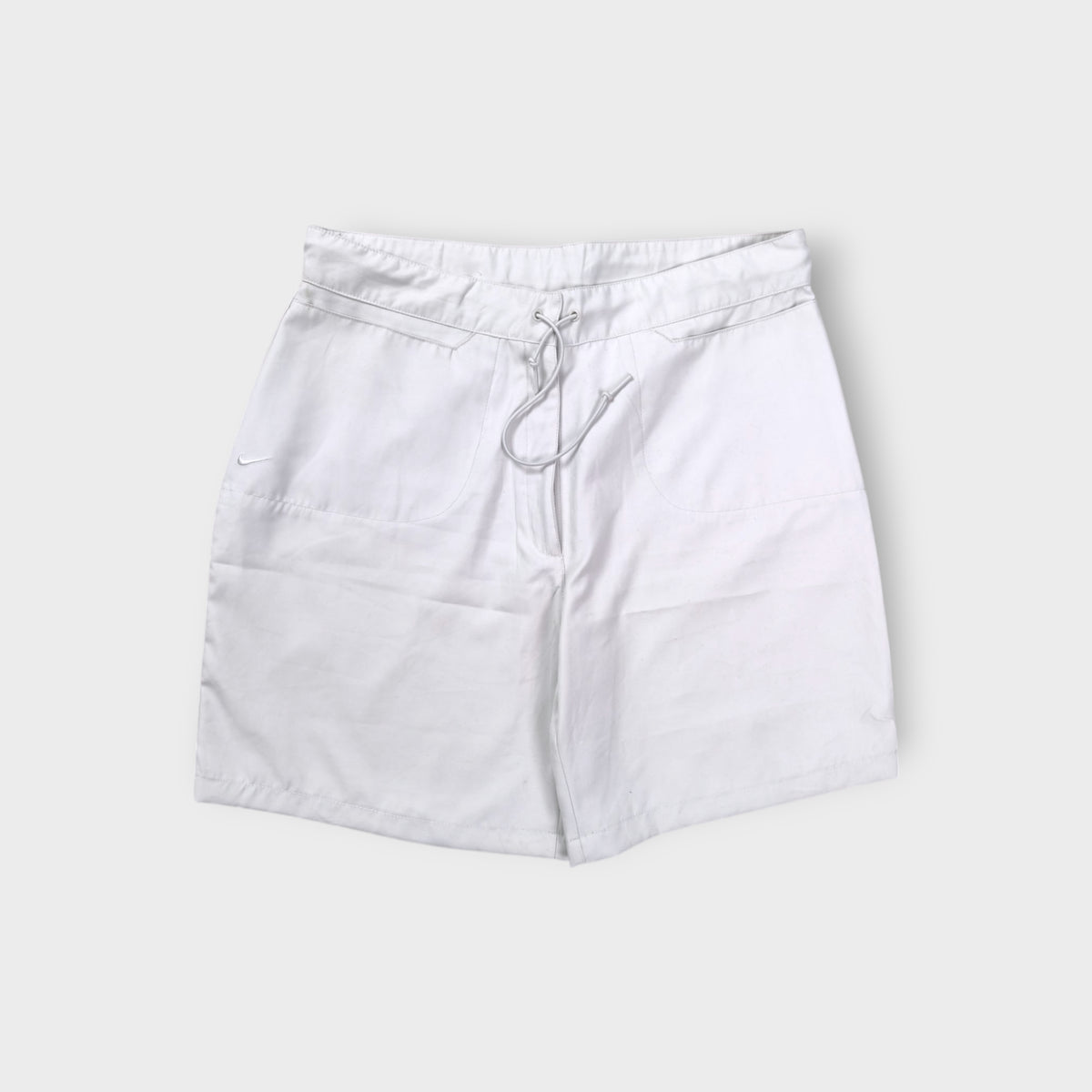 White Nike shorts featuring a small embroidered swoosh logo and front drawstring
