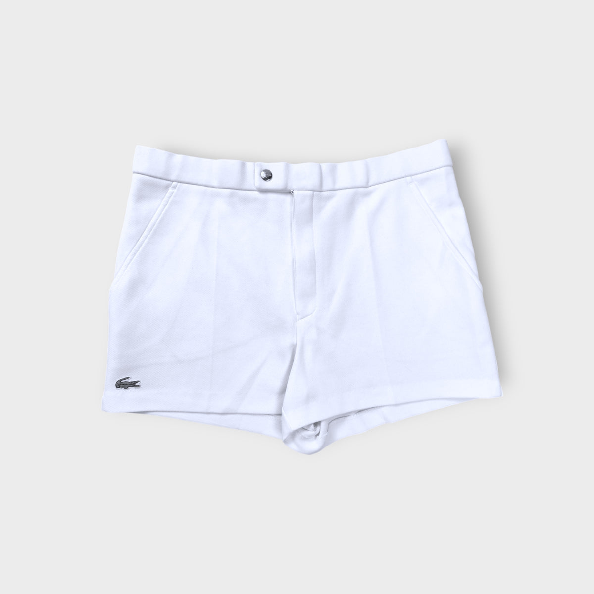 Lacoste shorts in white featuring an embroidered crocodile logo on the lower hem