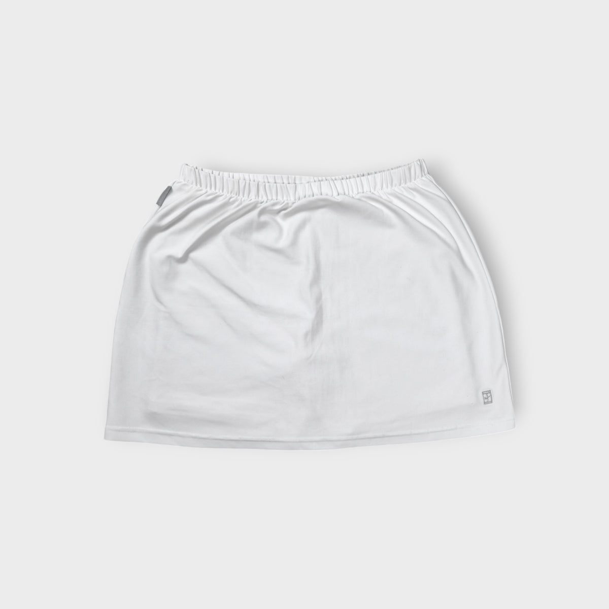 Nike white tennis skirt with elastic waistband and embroidered court logo at hem