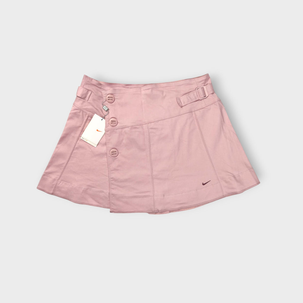 Pink Nike tennis skirt with decorative side buttons and an embroidered swoosh logo
