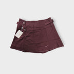 Nike women's tennis skirt in dark red with side button closures and waist buckles.