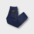 Blue Wrangler denim jeans featuring a leather logo patch on the back pocket.