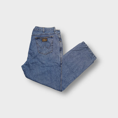 Wrangler blue denim jeans showing rear pockets with W stitching and leather patch
