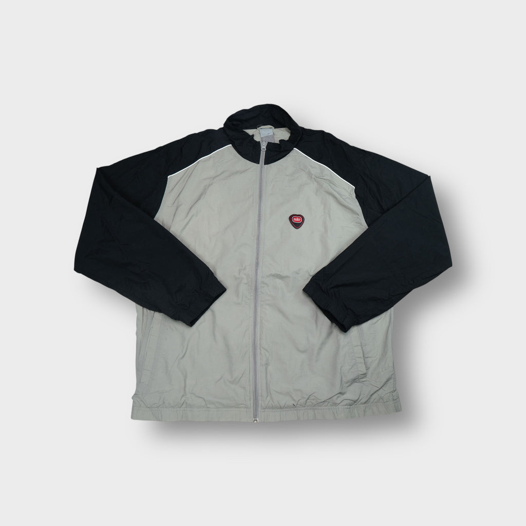 Nike track jacket in grey and black with a red shield logo patch on the chest