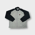 Nike track jacket in grey and black with a red shield logo patch on the chest