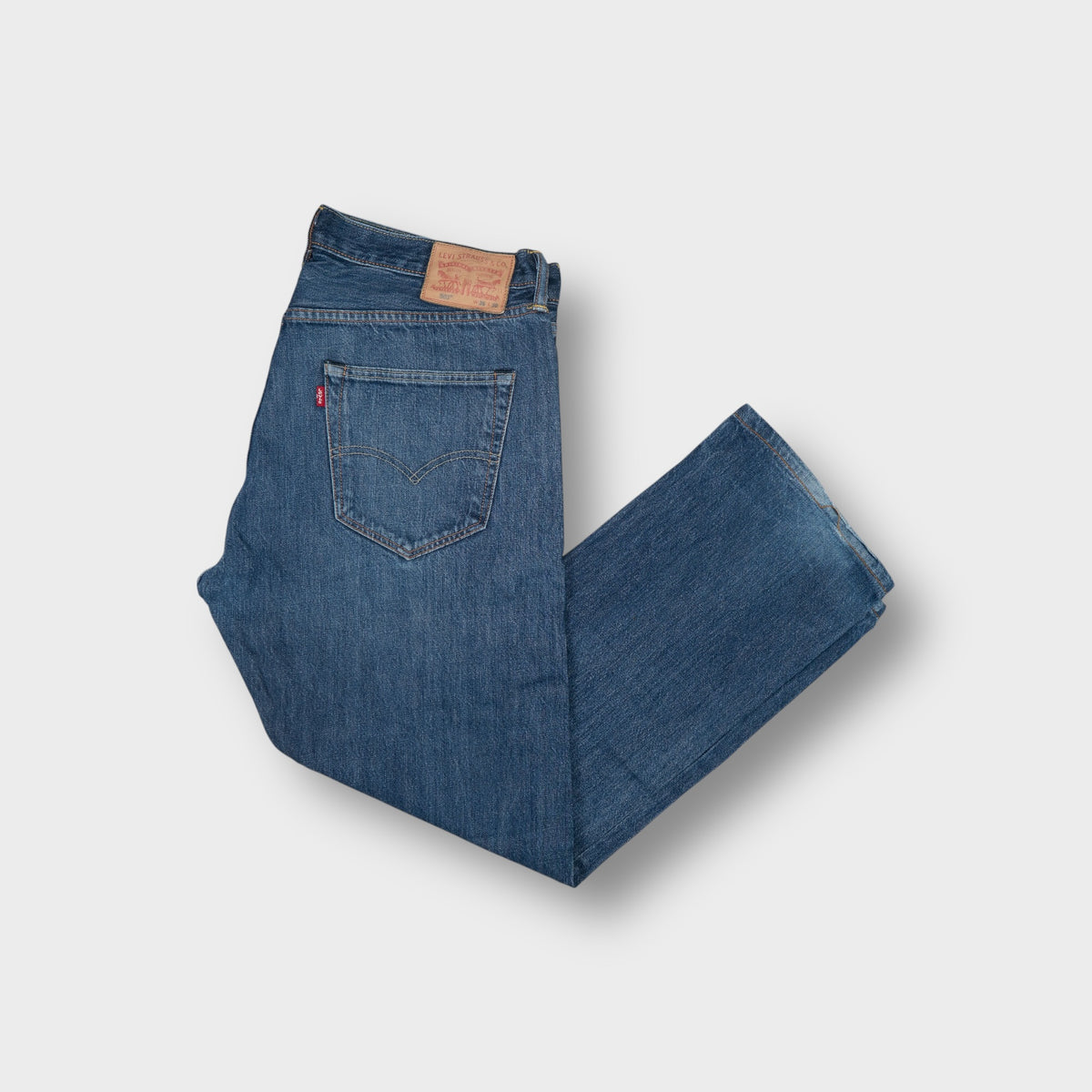 Levi's 501 jeans in blue denim featuring a small red tab and branded waistband patch.