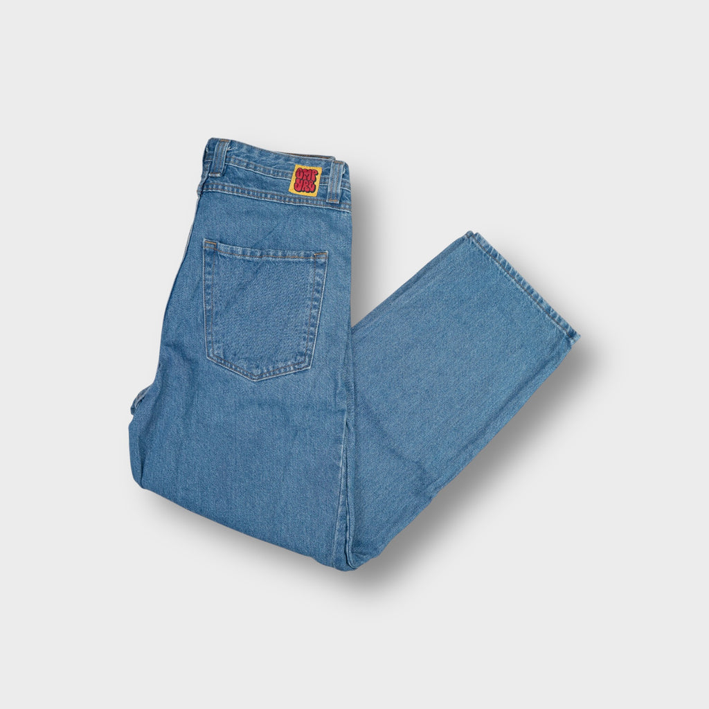 Empyre blue denim jeans featuring a red graffiti logo patch on the coin pocket.