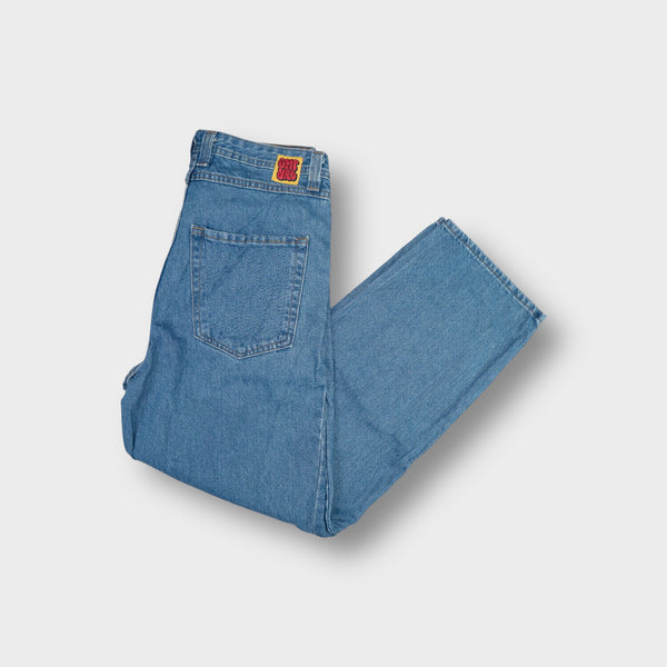 Empyre blue denim jeans featuring a red graffiti logo patch on the coin pocket.