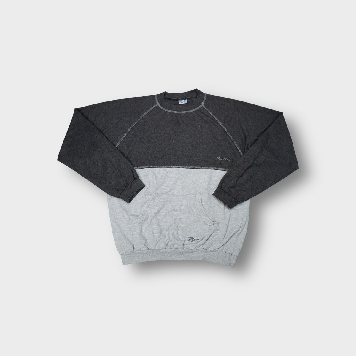 Grey Reebok sweater with contrasting paneling and front kangaroo pocket