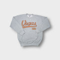 Gildan crew-neck sweater in grey featuring brown script Vegas USA lettering across the chest