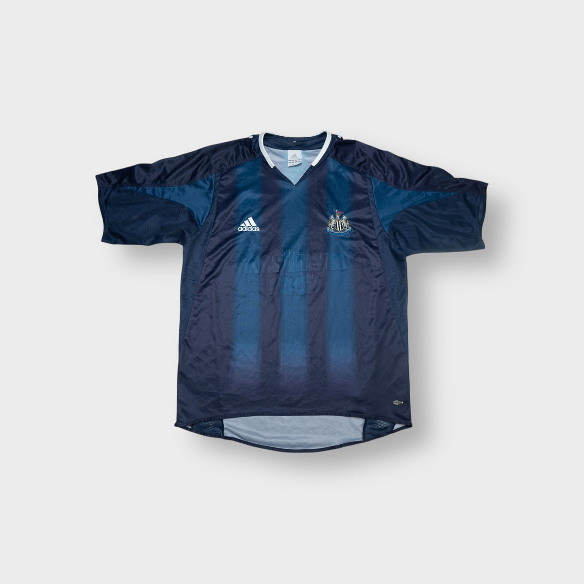 Adidas blue Newcastle United football shirt featuring an embroidered club crest and V-neck collar