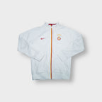 White Nike Galatasaray track jacket with embroidered crest and yellow and red zip trim