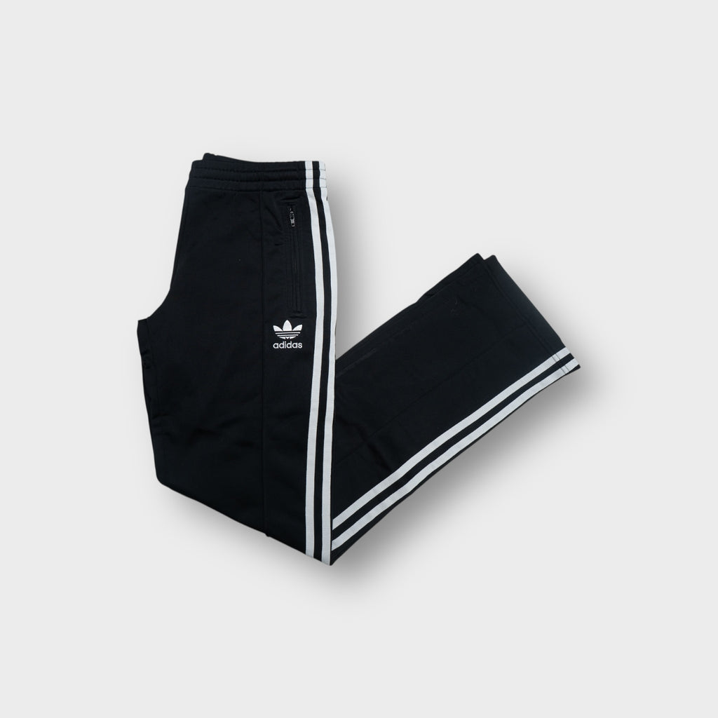 Black Adidas trackpants with white three stripes down the legs and trefoil logo embroidery