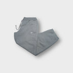Nike grey sweatpants with a white embroidered Swoosh logo near the side pocket