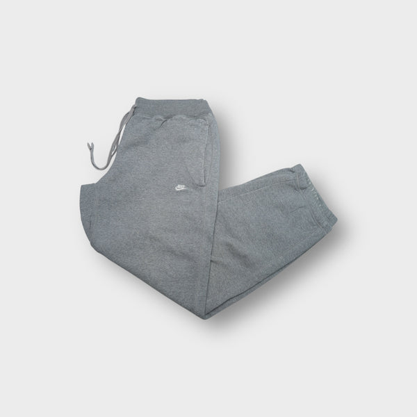 Nike grey sweatpants with a white embroidered Swoosh logo near the side pocket