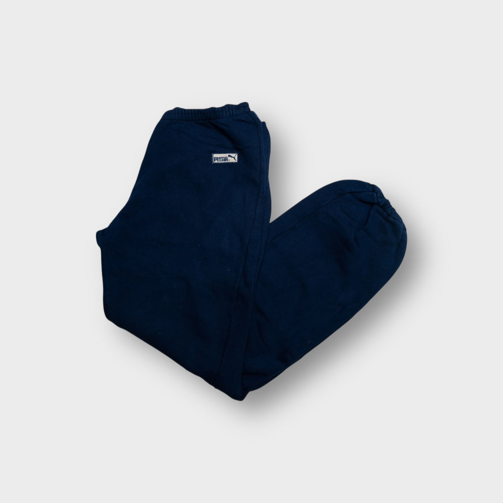Puma sweatpants in navy blue featuring a small woven logo patch at the hip