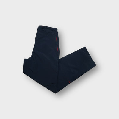 Nike navy blue track pants with red zipper detail and embroidered swoosh logo