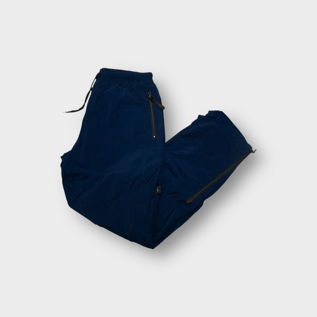 Nike navy blue trackpants featuring zipped side pockets and an elastic drawstring waist