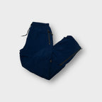Nike navy blue trackpants featuring zipped side pockets and an elastic drawstring waist