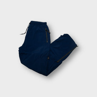 Nike navy blue trackpants featuring zipped side pockets and an elastic drawstring waist