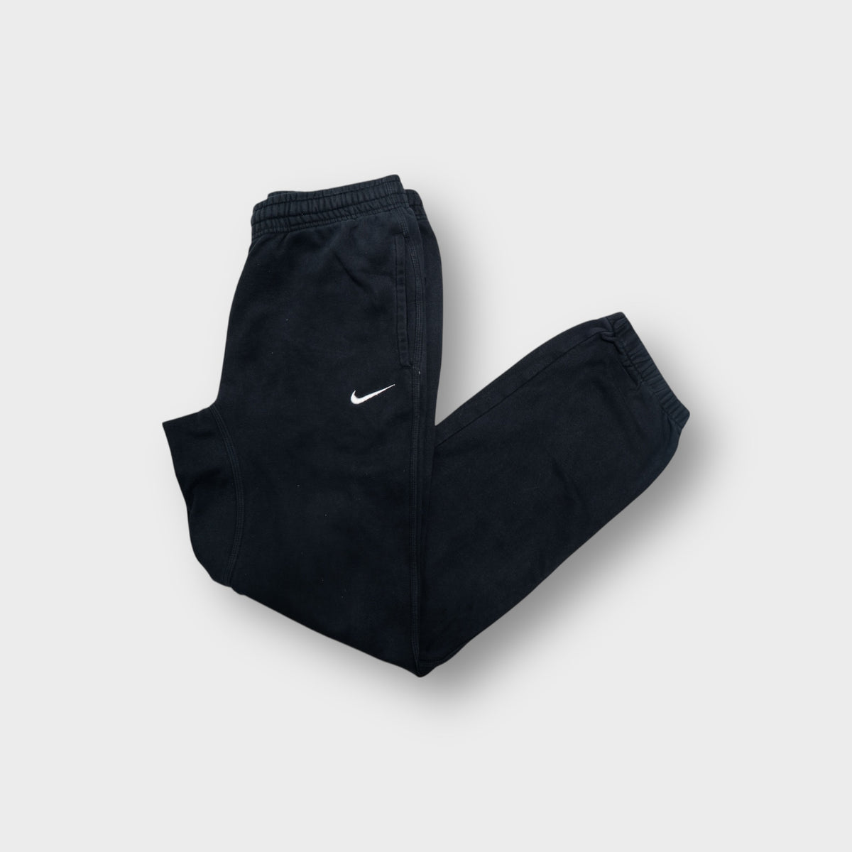 Nike sweatpants in black featuring a small white embroidered swoosh logo