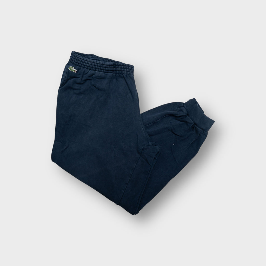 Lacoste sweatpants in navy blue featuring an embroidered crocodile logo on the hip.