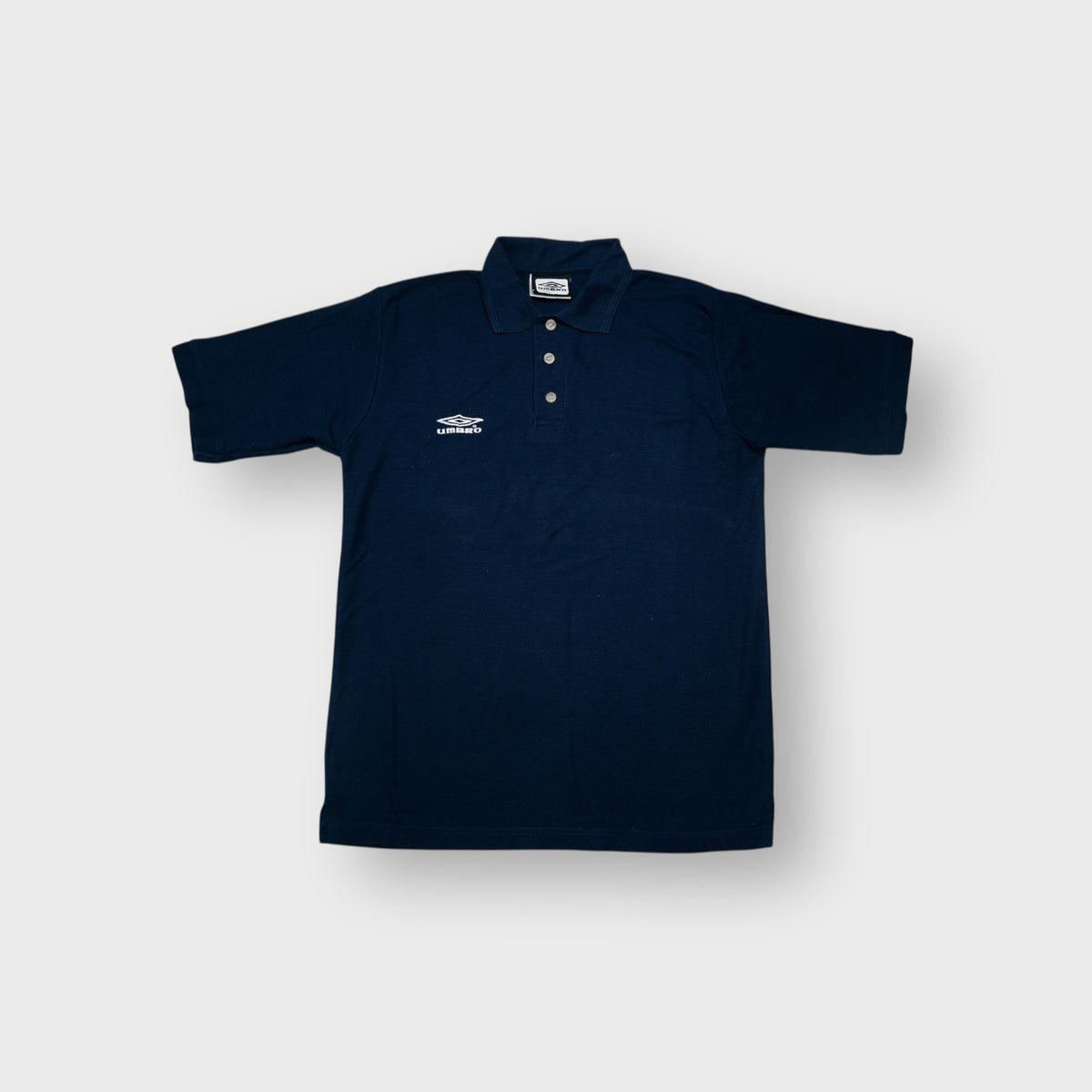 Umbro polo shirt in navy blue with an embroidered white chest logo.