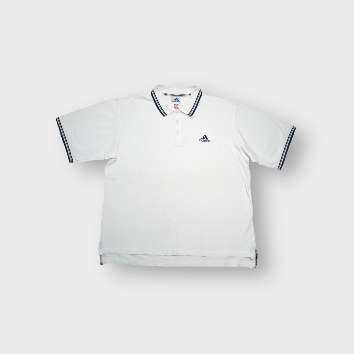 Adidas white polo shirt featuring striped collar trim and embroidered chest logo