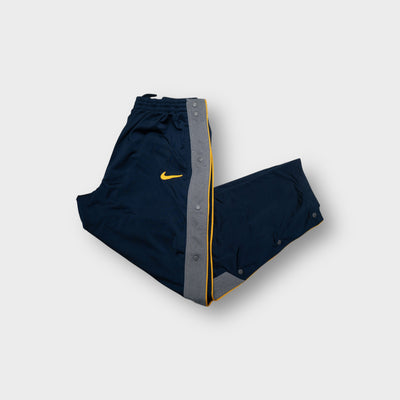 Nike navy blue trackpants with grey side snap panels and an embroidered yellow Swoosh