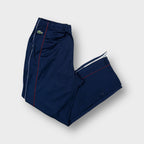 Lacoste trackpants in navy blue featuring an embroidered crocodile logo on the hip.