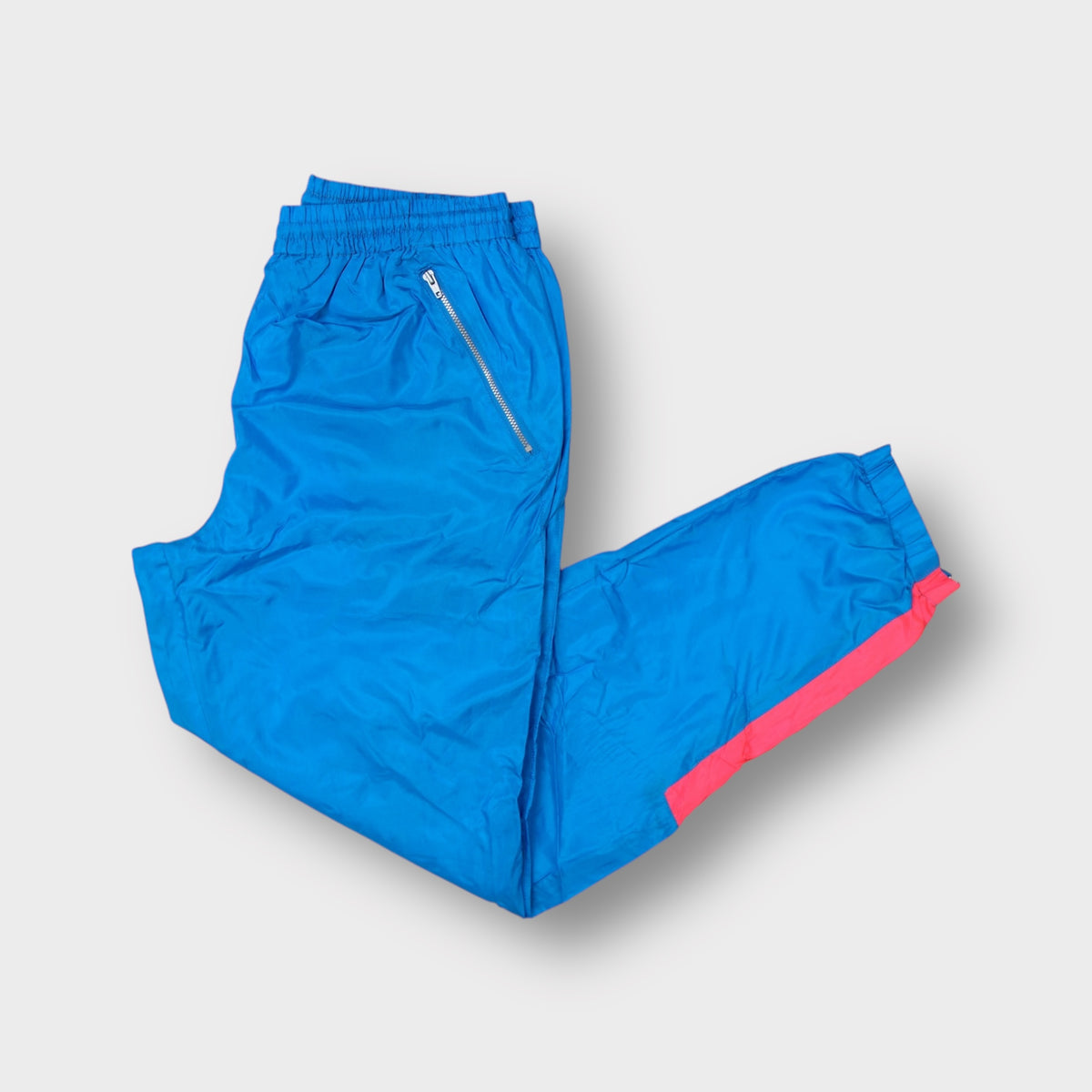 Vintage Nike blue trackpants featuring pink contrast panels and a Nike International patch
